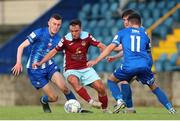 1 July 2022; Sean McGrath of Cobh Ramblers in action against  Lee Devitt, left, and Stephen Christopher of Treaty United during the SSE Airtricity League First Division match between Cobh Ramblers and Treaty United at St Colman's Park in Cobh, Cork. Photo by Michael P Ryan/Sportsfile