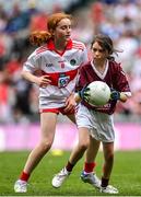 9 July 2022; Tori Molloy, Scoil Clann Naofa, Ballinamore, Leitrim, representing Galway, in action against Ellie McCarthy, Ballintemple N.S., Ballintemple, Cork, representing Derry, during the INTO Cumann na mBunscol GAA Respect Exhibition Go Games match during half-time of the GAA Football All-Ireland Senior Championship Semi-Final match between Galway and Derry at Croke Park in Dublin. Photo by Seb Daly/Sportsfile