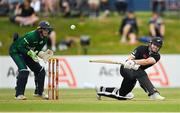 15 July 2022; Henry Nicholls of New Zealand plays a shot, watched by Ireland wicketkeeper Lorcan Tucker, during the Men's One Day International match between Ireland and New Zealand at Malahide Cricket Club in Dublin. Photo by Seb Daly/Sportsfile