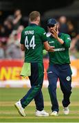 15 July 2022; Craig Young of Ireland, left, is congratulated by teammate Andrew Balbirnie after taking the wicket of New Zealand's Henry Nicholls during the Men's One Day International match between Ireland and New Zealand at Malahide Cricket Club in Dublin. Photo by Seb Daly/Sportsfile