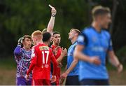 22 July 2022; Jack Keaney of UCD, right, is shown a red card by referee John McLoughlin during the SSE Airtricity League Premier Division match between UCD and Shelbourne at the UCD Bowl in Belfield, Dublin. Photo by Seb Daly/Sportsfile