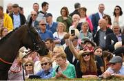 26 July 2022; Spectators look on as horses parade before the Colm Quinn BMW Novice Hurdle during day two of the Galway Races Summer Festival at Ballybrit Racecourse in Galway. Photo by Harry Murphy/Sportsfile