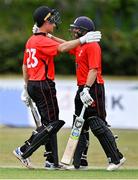 27 July 2022; Murray Commins of Munster Reds, left, celebrates with teammate Tyrone Kane after bringing up his century during the Cricket Ireland Inter-Provincial Trophy match between Leinster Lightning and Munster Reds at Pembroke Cricket Club in Dublin. Photo by Piaras Ó Mídheach/Sportsfile
