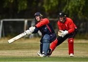 28 July 2022; John Matchett of Northern Knights plays a shot watched by Munster Reds wicketkeeper PJ Moor during the Cricket Ireland Inter-Provincial Trophy match between Munster Reds and Northern Knights at Pembroke Cricket Club in Dublin. Photo by Sam Barnes/Sportsfile