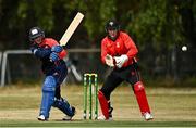 28 July 2022; James McCollum of Northern Knights, plays a shot watched by Munster Reds wicketkeeper PJ Moor during the Cricket Ireland Inter-Provincial Trophy match between Munster Reds and Northern Knights at Pembroke Cricket Club in Dublin. Photo by Sam Barnes/Sportsfile