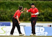 29 July 2022; Tyrone Kane of Munster Reds, lefts, celebrates with team-mate David Delany after catching out Jared Wilson of North West Warriors during the Cricket Ireland Inter-Provincial Trophy match between North West Warriors and Munster Reds at Pembroke Cricket Club in Dublin. Photo by Sam Barnes/Sportsfile