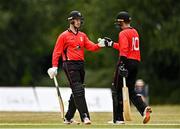 29 July 2022; Murray Commins of Munster Reds, left, and team-mate PJ Moor bump fists during the Cricket Ireland Inter-Provincial Trophy match between North West Warriors and Munster Reds at Pembroke Cricket Club in Dublin. Photo by Sam Barnes/Sportsfile