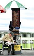 29 July 2022; A bookmaker studies the form prior to racing on day five of the Galway Races Summer Festival at Ballybrit Racecourse in Galway. Photo by Seb Daly/Sportsfile