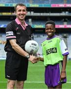 31 July 2022; Ball carrier Victor Adanikin presents the official match ball to referee Kevin Corcoran before the TG4 All-Ireland Ladies Football Junior Championship Final match between Antrim and Fermanagh at Croke Park in Dublin. Photo by Brendan Moran/Sportsfile