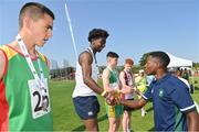 13 August 2022; Kenneth Kalu from Cornageeha, Sligo, is presented with his medal by Community Games ambassador Jesse Osas after winning the boys 100m U14 & O12 final during the Aldi Community Games National Track and Field Finals that attract over 2,000 children to SETU Carlow Sports Campus in Carlow. Photo by Ramsey Cardy/Sportsfile