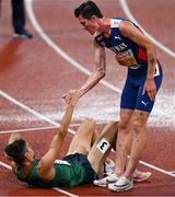 18 August 2022; Jakob Ingebrigtsen of Norway helps Andrew Coscoran of Ireland to his feet after the Men's 1500m Final during day 8 of the European Championships 2022 at the Olympiastadion in Munich, Germany. Photo by Ben McShane/Sportsfile