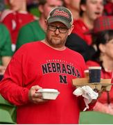 27 August 2022; A Nebraska Cornhuskers supporter carriers beer to his seat during the Aer Lingus College Football Classic 2022 match between Northwestern Wildcats and Nebraska Cornhuskers at Aviva Stadium in Dublin. Photo by Brendan Moran/Sportsfile