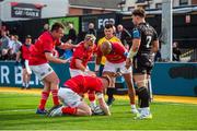 25 September 2022; Ben Healy of Munster, centre, is congratulated by team-mates after scoring his side's second try during the United Rugby Championship match between Dragons and Munster at Rodney Parade in Newport, Wales. Photo by Mark Lewis/Sportsfile