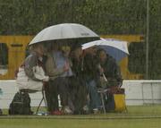 30 May 2004; Irish cricket fans shelter from the rain. C&G Trophy 3rd Round, Ireland v Northamptonshire CCC, Clontarf Cricket Club, Clontarf, Dublin. Picture credit; Pat Murphy / SPORTSFILE