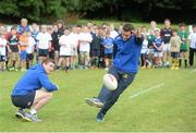 13 August 2013; Leinster's Fergus McFadden takes a kick at goal as team-mate Brian O'Driscoll and camp participants look on during a Leinster Rugby Summer Camp at DLSP RFC, Kirwan Park, Kilternan, Co. Dublin. Picture credit: Brian Lawless / SPORTSFILE
