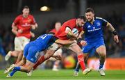 22 October 2022; Diarmuid Barron of Munster is tackled by  Jimmy O'Brien, left, and Andrew Porter of Leinster during the United Rugby Championship match between Leinster and Munster at Aviva Stadium in Dublin. Photo by Ramsey Cardy/Sportsfile