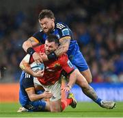 22 October 2022; Diarmuid Barron of Munster is tackled by  Jimmy O'Brien, below, and Andrew Porter of Leinster during the United Rugby Championship match between Leinster and Munster at Aviva Stadium in Dublin. Photo by Ramsey Cardy/Sportsfile