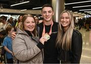 7 November 2022; Gold medallist Rhys McClenaghan of Ireland with his mother Tracy and girlfriend Emily Carr on his return from the World Artistic Gymnastics Championships 2022, at Dublin Airport in Dublin. Photo by David Fitzgerald/Sportsfile
