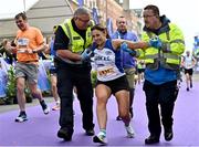30 October 2022; Karen Greene from Lusk AC is helped over the finish line during the 2022 Irish Life Dublin Marathon. 25,000 runners took to the Fitzwilliam Square start line to participate in the 41st running of the Dublin Marathon after a two-year absence. Photo by Sam Barnes/Sportsfile