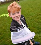 13 November 2022; Ed Keegan, age 8, with his sling signed by Leinster Rugby player Ross Byrne during a Dundalk RFC Minis training session at Dundalk RFC in Dundalk, Louth. Photo by Ramsey Cardy/Sportsfile