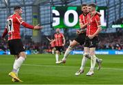 13 November 2022; Jamie McGonigle of Derry City, right, celebrates with teammates Ronan Boyce, second right, and Ryan Graydon, left, after scoring their side's first goal during the Extra.ie FAI Cup Final match between Derry City and Shelbourne at the Aviva Stadium in Dublin. Photo by Seb Daly/Sportsfile