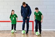 24 November 2022; Republic of Ireland international Evan Ferguson with pupils Cillian Walsh and Roisin O'Reilly from Scoil Chiaráin during the launch of Football for All - Futsal in the Yard programme at the Scoil Chiaráin in Glasnevin, Dublin. Photo by Eóin Noonan/Sportsfile