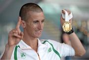 16 August 2013; Ireland's Robert Heffernan with his men's 50k walk gold medal in Dublin airport on his return from the IAAF World Athletics Championships in Moscow. Dublin Airport, Dublin. Picture credit: Brian Lawless / SPORTSFILE