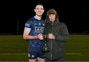 21 December 2022; Dublin North captain Brian Fenton is presented with the trophy by former Dublin footballer Dave Hickey after victory in the Dave Hickey Cup Final match between Dublin North and Dublin South at the Dublin City University Sports Campus in Dublin. Photo by Seb Daly/Sportsfile