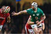 4 February 2023; Mack Hansen of Ireland offloads as he is tackled by Alex Cuthbert of Wales during the Guinness Six Nations Rugby Championship match between Wales and Ireland at Principality Stadium in Cardiff, Wales. Photo by Brendan Moran/Sportsfile