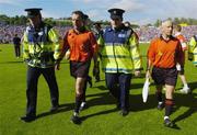 6 June 2004; Referee Diarmuid Kirwan, centre, and his linesmen are escorted from the pitch after the game by Gardai. Guinness Munster Senior Hurling Championship Semi-Final, Tipperary v Waterford, Pairc Ui Chaoimh, Cork. Picture credit; Brendan Moran / SPORTSFILE