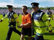 6 June 2004; Referee Diarmuid Kirwan is escorted off the pitch at the end of the game by Gardai. Guinness Munster Senior Hurling Championship Semi-Final, Tipperary v Waterford, Pairc Ui Chaoimh, Cork. Picture credit; Brendan Moran / SPORTSFILE
