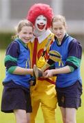 9 June 2004; Caoimhe Rathbone, 13 years, and Eva Nugent, 12, St Pius, Tempelogue, Dublin, with Ronald McDonald at the Dublin final of the McDonalds Lift & Strike Competition. Parnell Park, Dublin. Picture credit; Ray McManus / SPORTSFILE