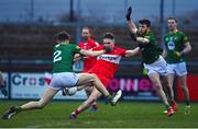 18 February 2023; Ethan Doherty of Derry scores his side's first goal despite the tackles of Adam O'Neill, 2, and Jack O'Connor of Meath during the Allianz Football League Division Two match between Derry and Meath at Derry GAA Centre of Excellence in Owenbeg, Derry. Photo by Ben McShane/Sportsfile