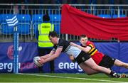 20 February 2023; Charlie O'Loughlin of Newbridge College dives over to score his side's eighth try despite the tackle of Riley Scales of CBC Monkstown during the Bank of Ireland Leinster Rugby Schools Senior Cup Quarter Final match between CBC Monkstown and Newbridge College at Energia Park in Dublin. Photo by Harry Murphy/Sportsfile