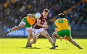 26 February 2023; Dylan McHugh of Galway in action against Daire Ó Baoill, left, and Caolan McGonagle of Donegal during the Allianz Football League Division 1 match between Donegal and Galway at O'Donnell Park in Letterkenny, Donegal. Photo by Ben McShane/Sportsfile