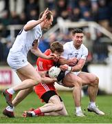 26 February 2023; Brendan Rogers of Derry is tackled by Paul Cribbin, left, and Ben McCormack of Kildare during the Allianz Football League Division 2 match between Kildare and Derry at St Conleth's Park in Newbridge, Kildare. Photo by Piaras Ó Mídheach/Sportsfile