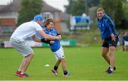 23 August 2013; Leinste's Jamie Heaslip tags André Ryan age 8, from Clontarf, Dublin, as team-mate Ian Madigan looks on during a Leinster Rugby Summer Camp at Clontarf RFC, Clontarf, Co. Dublin. Picture credit: Brian Lawless / SPORTSFILE
