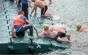 24 August 2013; Breffni O'Reilly, Glenalbyn Masters, is helped from the water after the 94th Dublin City Liffey Swim. River Liffey, Dublin. Picture credit: Brian Lawless / SPORTSFILE