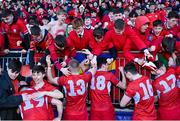 10 March 2023; CUS players celebrate with supporter after their side's victory in the Bank of Ireland Vinnie Murray Cup Final match between CUS and St Andrew's College at Energia Park in Dublin. Photo by Seb Daly/Sportsfile