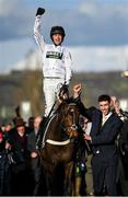 14 March 2023; Jockey Nico de Boinville celebrates on Constitution Hill as they are led into the winners enclosure by Jaydon Lee after the Unibet Champion Hurdle Challenge Trophy during day one of the Cheltenham Racing Festival at Prestbury Park in Cheltenham, England. Photo by Seb Daly/Sportsfile