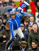 15 March 2023; Jockey Paul Townend celebrates on Energumene, as they are led into the winner's enclosure by groom Imran Haider, right, after winning the Betway Queen Mother Champion Chase during day two of the Cheltenham Racing Festival at Prestbury Park in Cheltenham, England. Photo by Seb Daly/Sportsfile