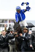 15 March 2023; Jockey Paul Townend celebrates on Energumene, as they are led into the winner's enclosure by owner Tony Bloom, left, and groom Imran Haider, right, after winning the Betway Queen Mother Champion Chase during day two of the Cheltenham Racing Festival at Prestbury Park in Cheltenham, England. Photo by Harry Murphy/Sportsfile