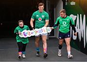 17 March 2023; Josh van der Flier, centre, and Craig Casey, walk out with Ireland supporter Jennifer Malone, in aid of the 'Lots of Socks' campaign during the Ireland rugby captain's run at the Aviva Stadium in Dublin. Photo by Ramsey Cardy/Sportsfile