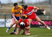 19 March 2023; Derry players Christopher McKaigue, centre, and Conor Doherty in action against Keelan Sexton of Clare during the Allianz Football League Division 2 match between Derry and Clare at Derry GAA Centre of Excellence in Owenbeg, Derry. Photo by Ben McShane/Sportsfile