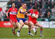 19 March 2023; Paul Cassidy of Derry is tackled by Eoin Cleary of Clare during the Allianz Football League Division 2 match between Derry and Clare at Derry GAA Centre of Excellence in Owenbeg, Derry. Photo by Ben McShane/Sportsfile