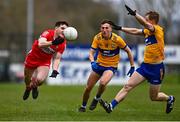 19 March 2023; Padraig McGrogan of Derry gets a pass away despite the attention of Emmet McMahon, centre, and Pearse Lillis of Clare during the Allianz Football League Division 2 match between Derry and Clare at Derry GAA Centre of Excellence in Owenbeg, Derry. Photo by Ben McShane/Sportsfile