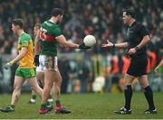 19 March 2023; Aidan O'Shea of Mayo hands the match ball to Referee Sean Hurson at the end of the first half of the Allianz Football League Division 1 match between Donegal and Mayo at MacCumhaill Park in Ballybofey, Donegal. Photo by Ramsey Cardy/Sportsfile