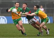 19 March 2023; Jordan Flynn of Mayo in action against Hugh McFadden, left, and Caolan Ward of Donegal during the Allianz Football League Division 1 match between Donegal and Mayo at MacCumhaill Park in Ballybofey, Donegal. Photo by Ramsey Cardy/Sportsfile