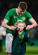 22 March 2023; Evan Ferguson of Republic of Ireland puts his anthem jacket on a young mascot during a shower of rain before the international friendly match between Republic of Ireland and Latvia at Aviva Stadium in Dublin. Photo by Stephen McCarthy/Sportsfile