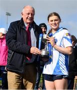 25 March 2023; Maynooth captain Casey Noone is presented the cup by Pat Quill, representing the LGFA, after the Lidl LGFA Post Primary Junior B Final match between Maynooth Educate Together, Kildare, and St Ronan's College Lurgan, Armagh at the GAA National Games Development Centre in Abbotstown, Dublin. Photo by Ben McShane/Sportsfile